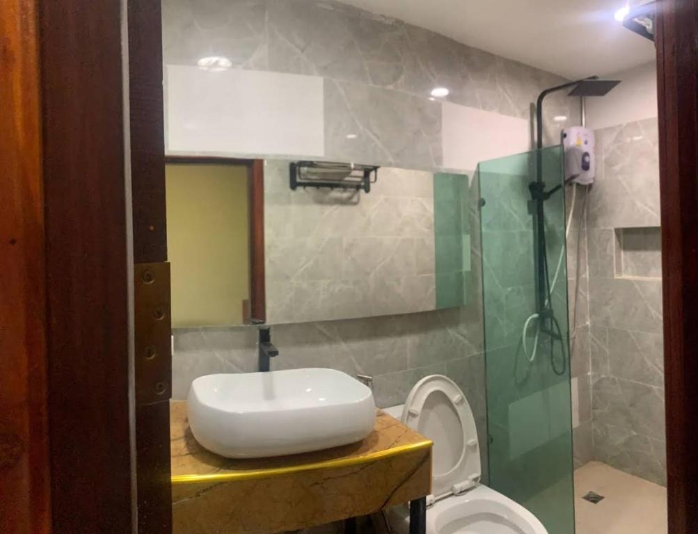 a bathroom with a sink and a toilet at Zhejiang Pakxe Hotel in Pakse