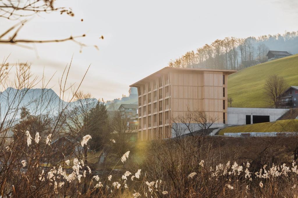 a building on a hill next to a field at Hotel Kurhaus am Sarnersee in Sarnen