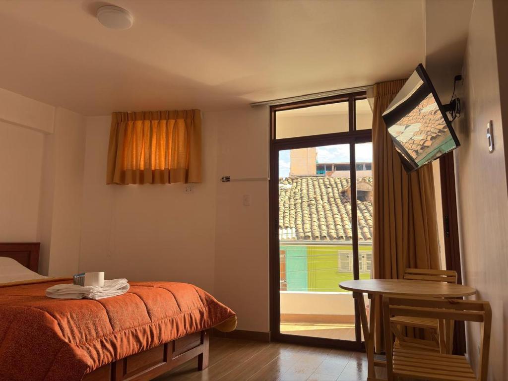 a bedroom with a bed and a sliding glass door at LOS NEVADOS II in Huaraz