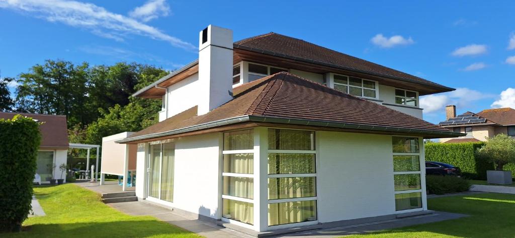 a white house with a brown roof at Thibault 1 in Gistel