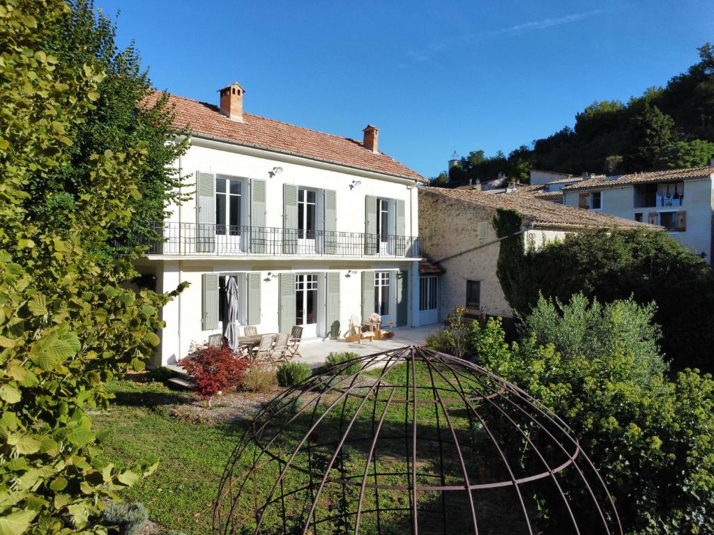 a large white house with a fence in the yard at Le Nid d'Estoublon in Estoublon