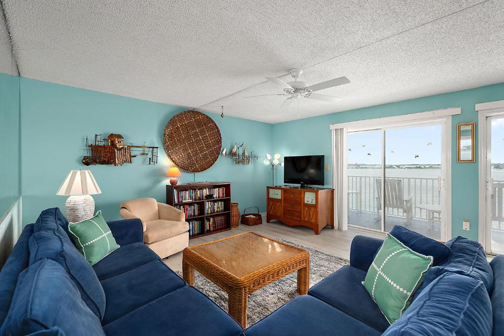 a living room with a blue couch and a tv at Crab Cove 302 in Ocean City