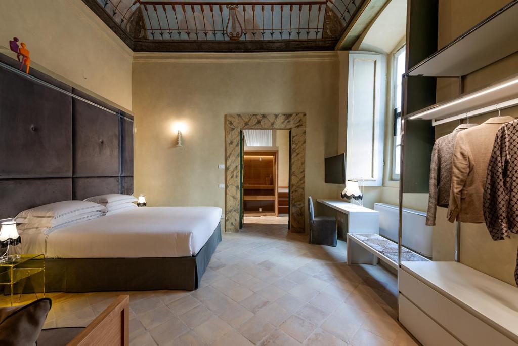a bedroom with a large bed and a bathroom at Palazzo Sbaraglini in Assisi