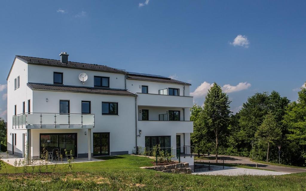 ein großes weißes Gebäude mit Bäumen im Hintergrund in der Unterkunft Gästehaus Turmblick in Bad Abbach