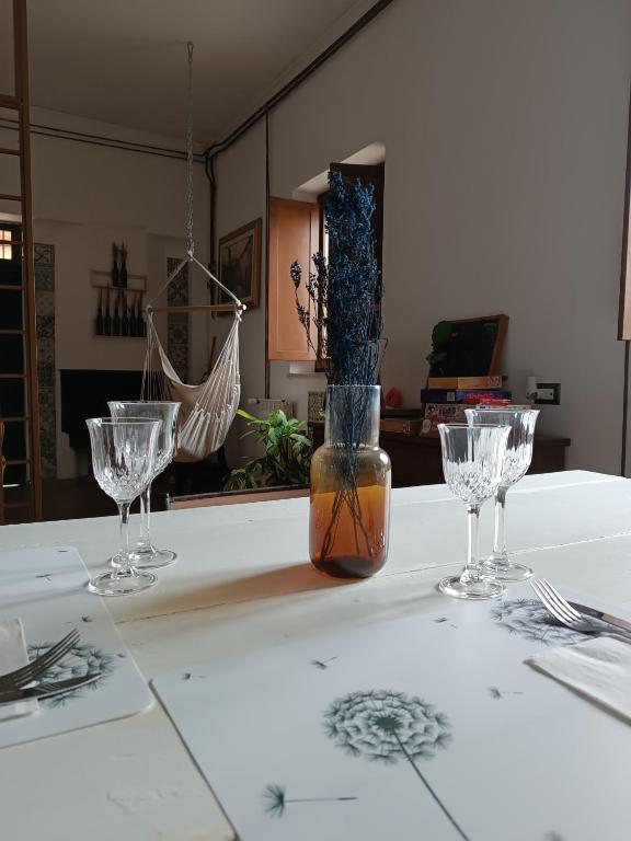 a table with three wine glasses and a vase on it at Casale del Tempo Lento in Narni