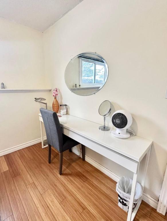 a white desk with a mirror and a chair at Cozy & Private Full Floor at Minnow Lake in Sudbury