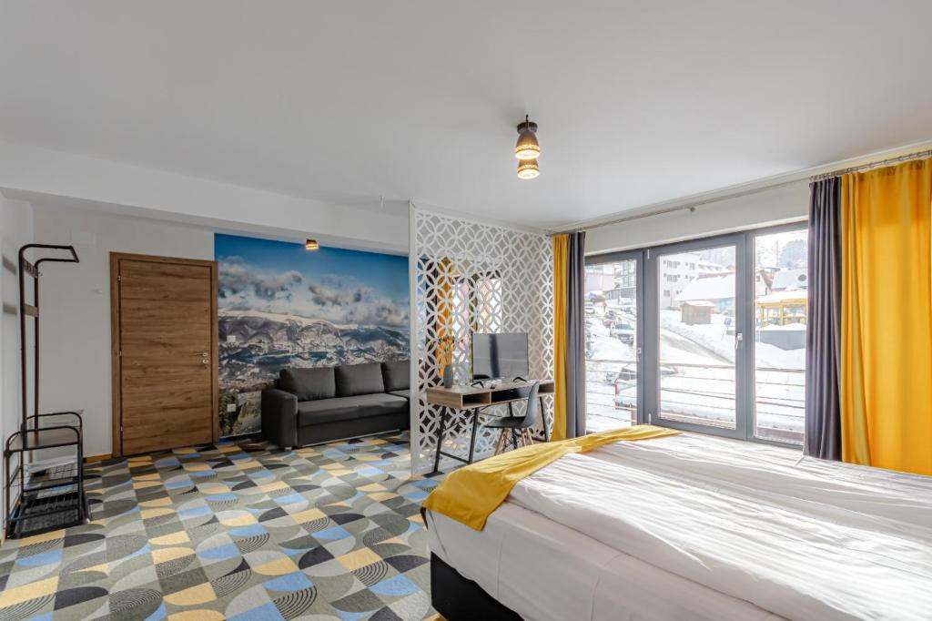 a bedroom with a large bed and a couch at Cabana Valea Lupilor in Straja