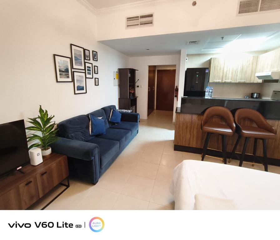 a living room with a blue couch and a kitchen at Downtown Dubai Mall walk & Burj Khalifa DIFC 5 mins in Dubai