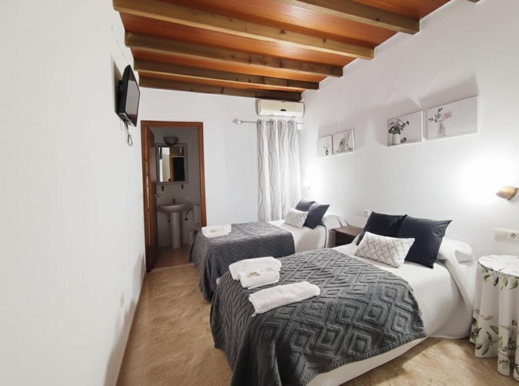 a hotel room with two beds and a table at Alojamiento Acuario in Espiel