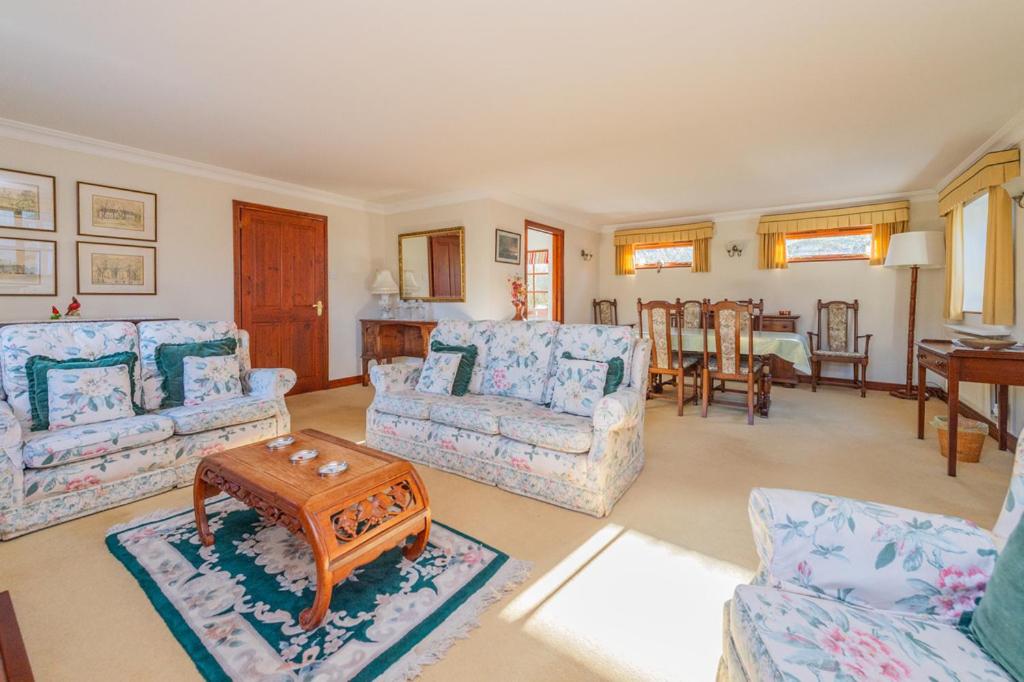 a living room with two couches and a table at Willow Cottage in North Lydbury