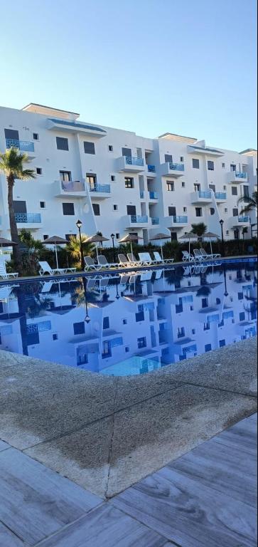 a large apartment building with a swimming pool at Appartement OCEANICA RESIDENCES in Marina Smir