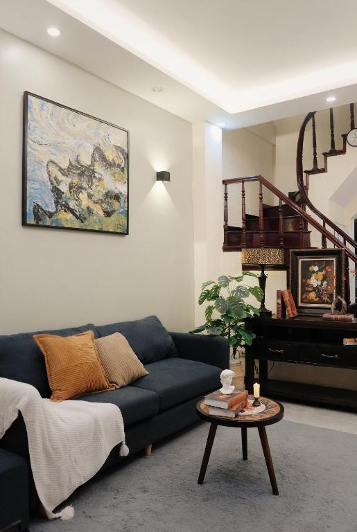 a living room with a blue couch and a piano at Toda House - 4Bedroom near Hoan Kiem Lake in Hanoi