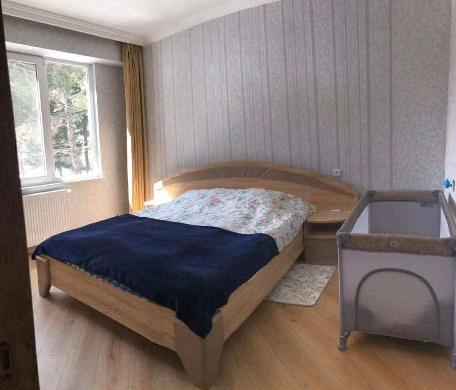 a bedroom with a bed and a desk and a window at mtatsminda residence in Itʼkhvisi