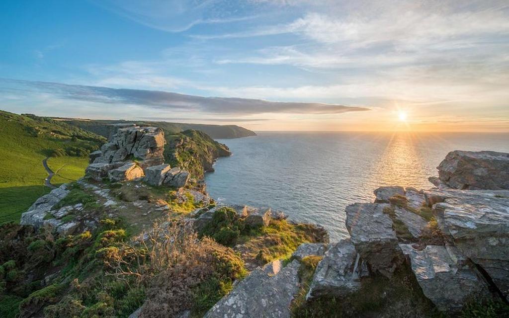 an island in the ocean with the sun setting at 2 Bed in Lynton oc-chap in Lynmouth