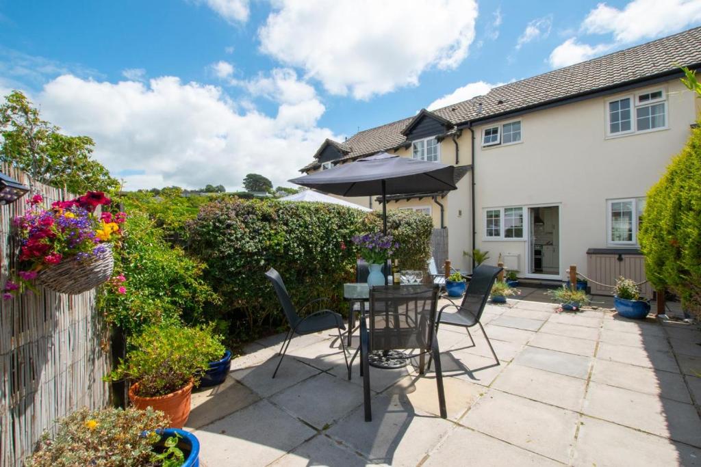 a patio with a table and chairs and an umbrella at 2 Bed in Instow oc-stones in Instow