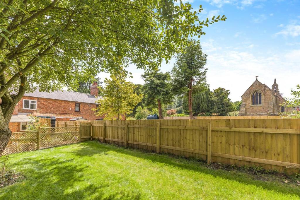 a wooden fence in front of a yard with a church at 2 Bed in Neenton oc-s29533 in Neenton