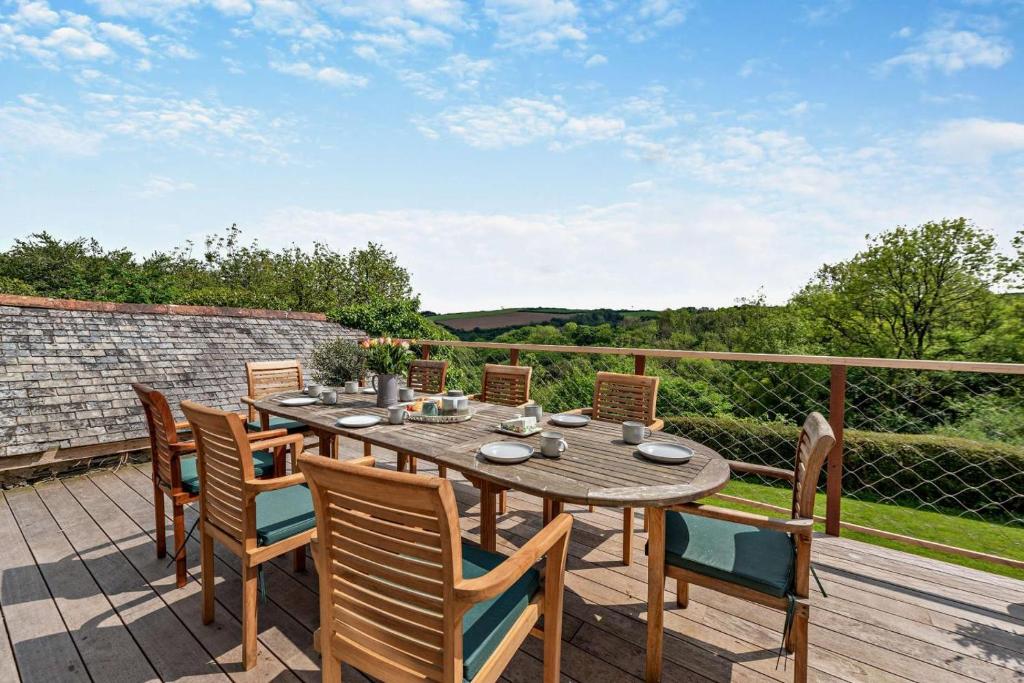 a wooden table and chairs on a wooden deck at 4 Bed in Goodleigh oc-e29107 in Goodleigh
