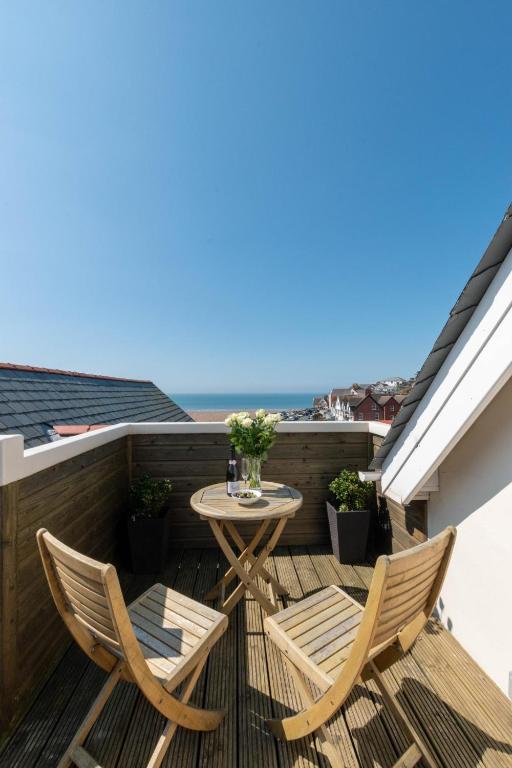 a patio with two chairs and a table on a balcony at 1 Bed in Woolacombe oc-seablu in Woolacombe