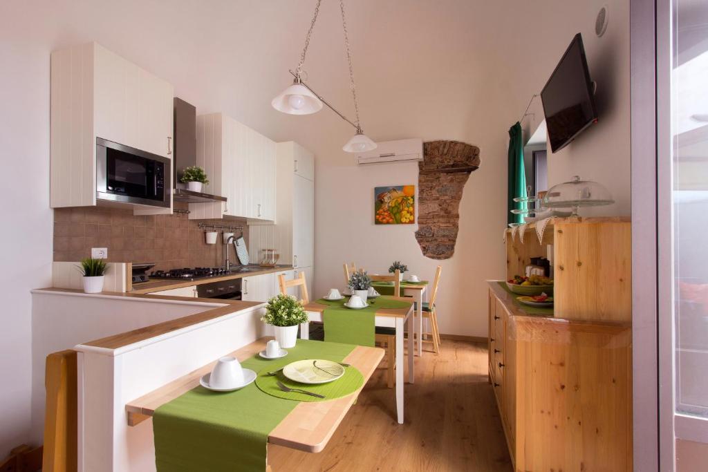 uma cozinha com uma pequena mesa e uma bancada verde em Cianciana em Catânia