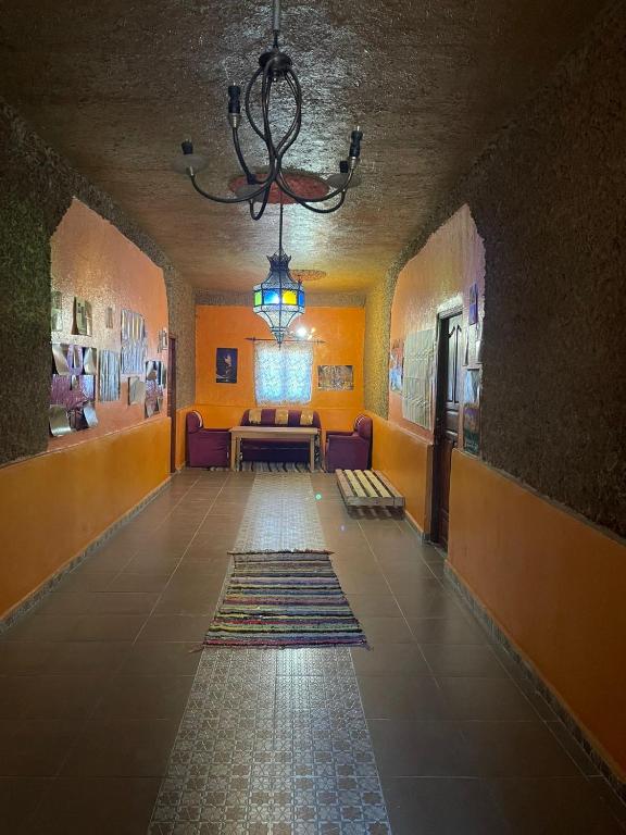 a hallway with a room with a couch and a chandelier at Guesthousefamillytakojt in Merzouga
