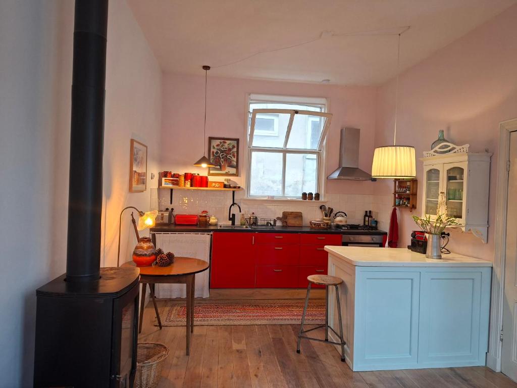 a kitchen with red cabinets and a stove at Casa di Kola in Zutphen