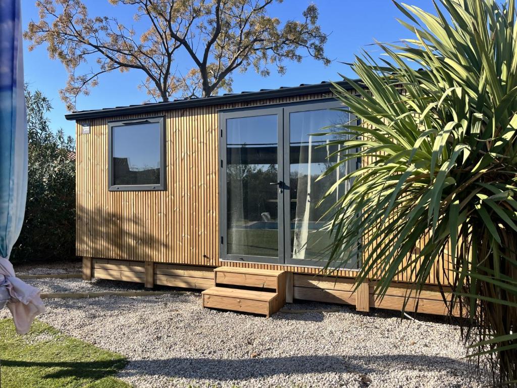 a tiny house sitting on top of a gravel yard at La Tiny de la chicorée in Paulhan