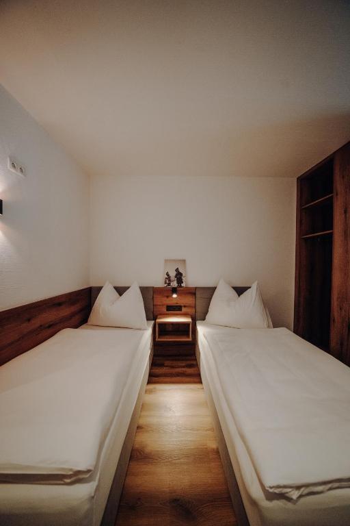 two twin beds in a room with a table at Kleinberg Chalet in Filzmoos