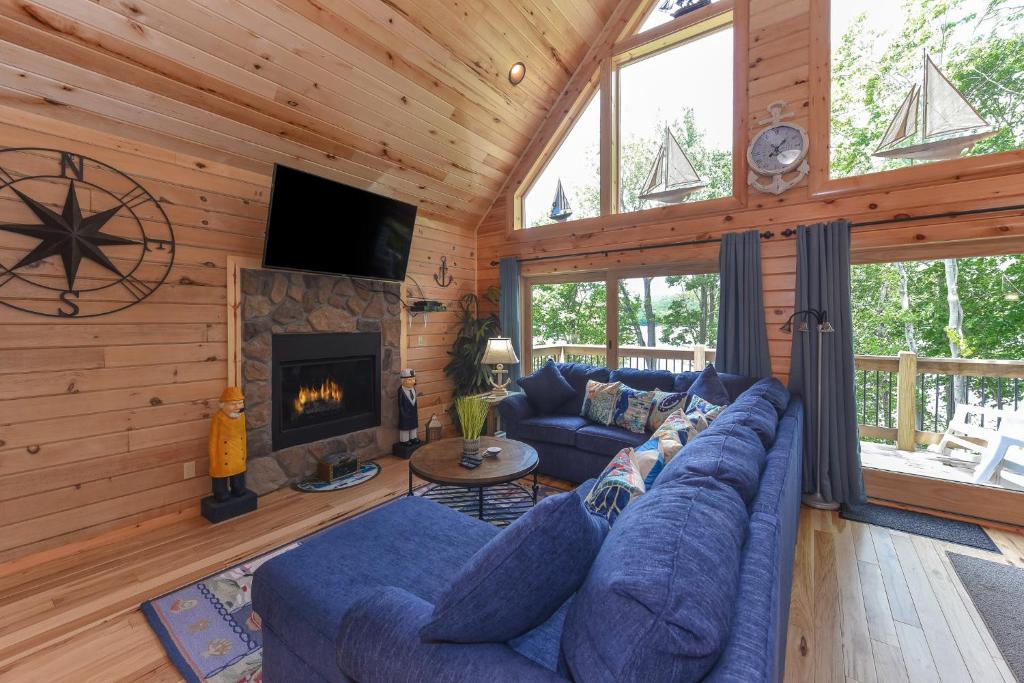 a living room with a blue couch and a fireplace at Captains Quarters by Railey Vacations in Oakland
