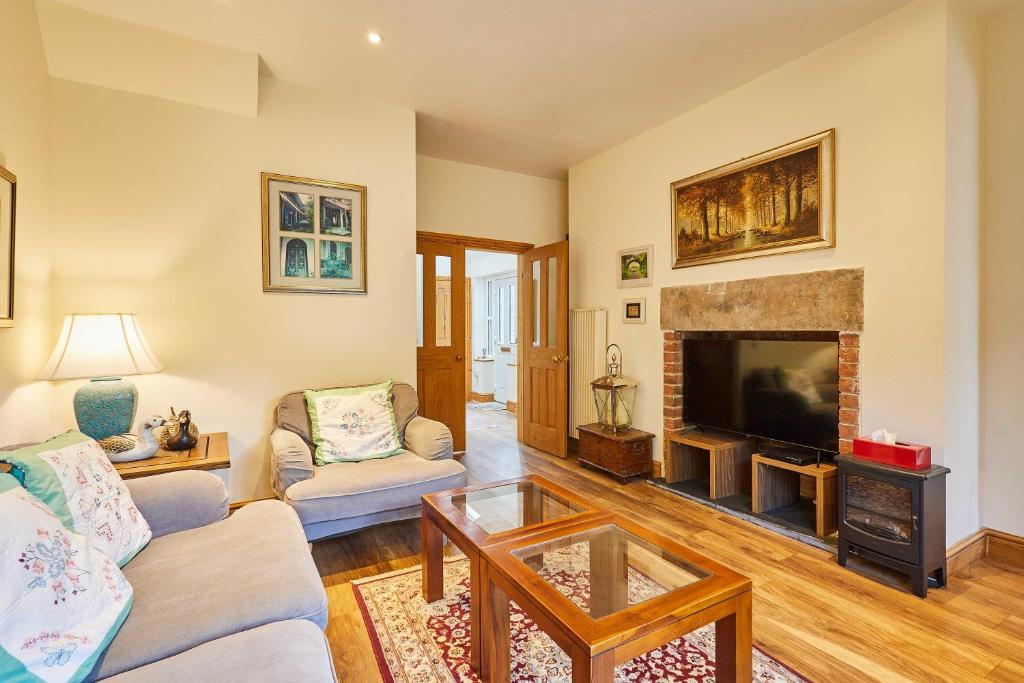 a living room with a fireplace and a tv at Host & Stay - The Station Cottage in Stanley