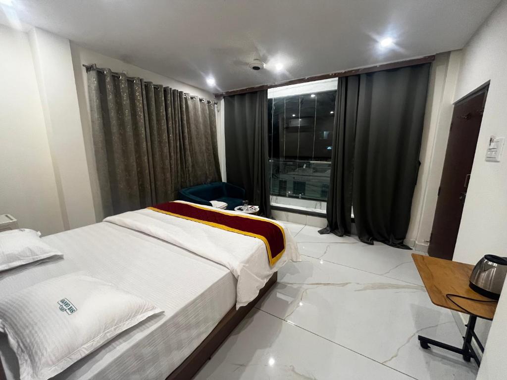a hotel room with two beds and a window at HOTEL SVR grand in Puttaparthi