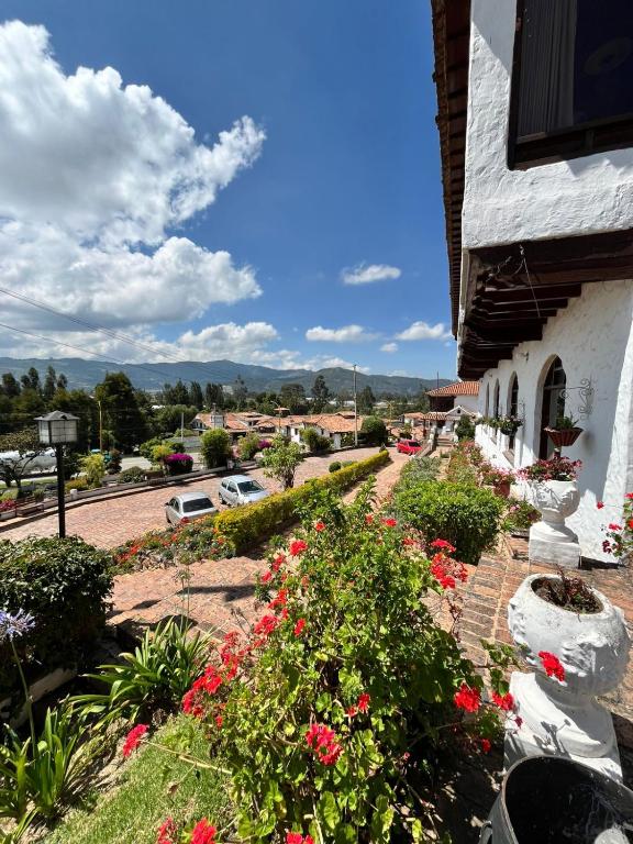 a house with flowers on the side of a street at Hotel Puntalarga PGB in Nobsa