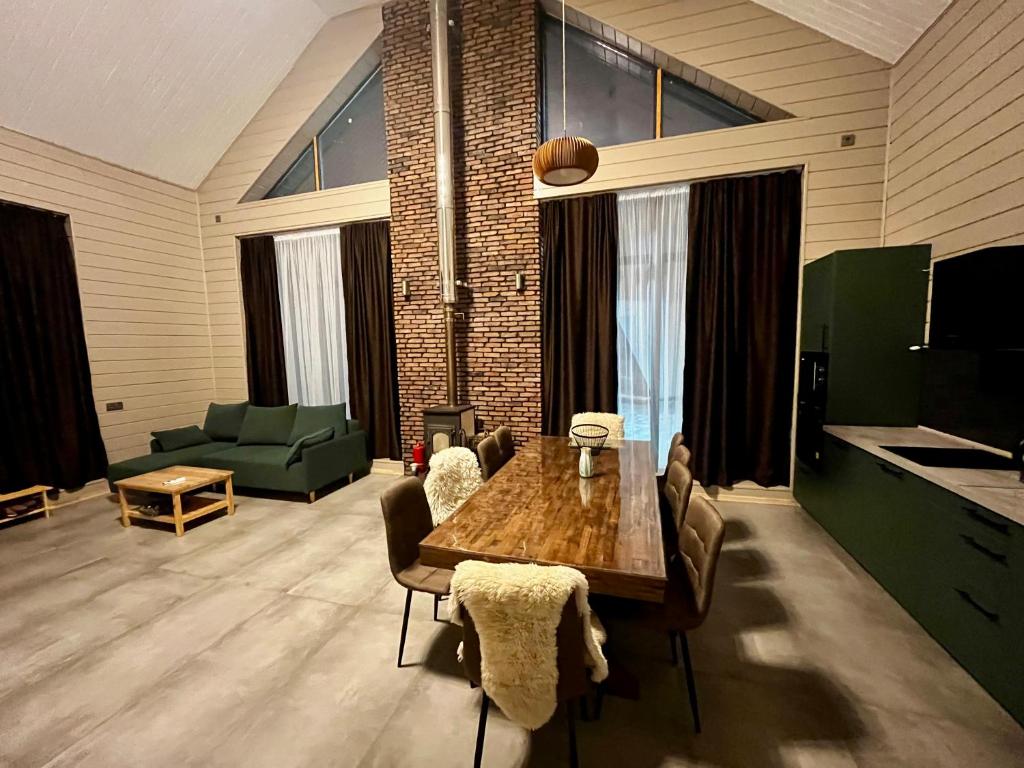 a living room with a wooden table and a green couch at Chalet 1391 in Ryskulovo