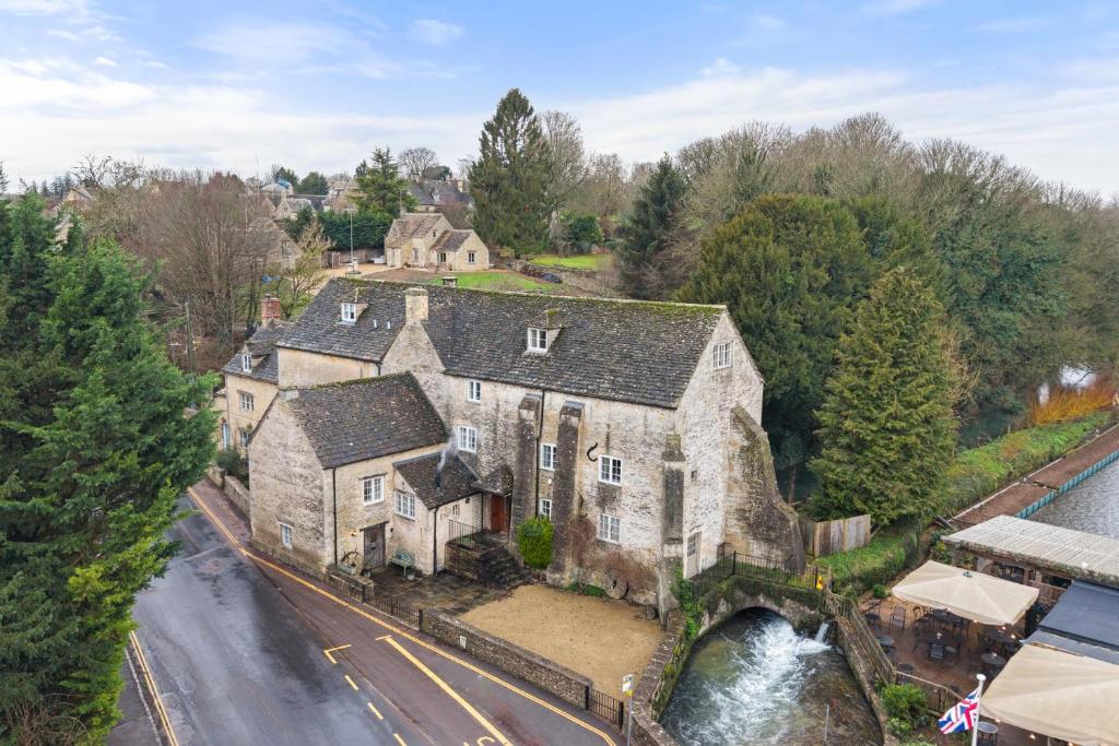 an aerial view of an old stone house with a bridge at Arlington Mill in Bibury