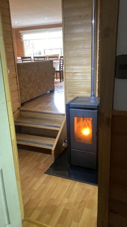 a woodburning stove in a room with a staircase at Cabañas lugar de Refugio in Queilén