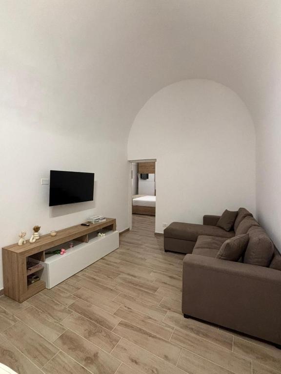 a living room with a couch and a flat screen tv at Vicolo Lungo Apartment in Nardò