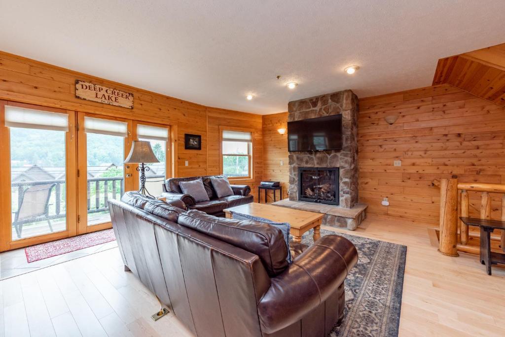 a living room with a leather couch and a fireplace at Cedar Shores Villa #19 by Railey Vacations in McHenry