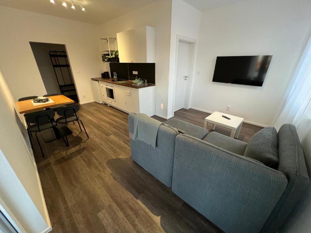 a living room with a couch and a kitchen at Apartmány ASTRA in Cheb