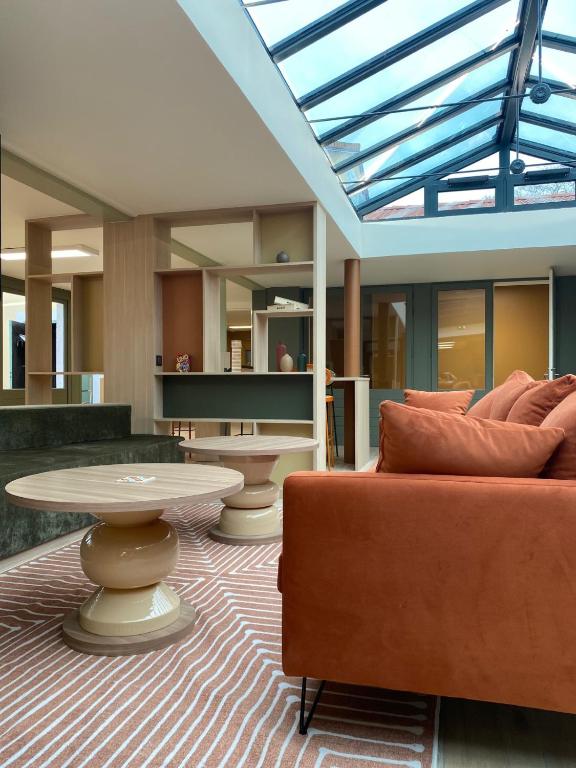 a living room with a couch and a table at Green Hôtels Poitiers in Poitiers