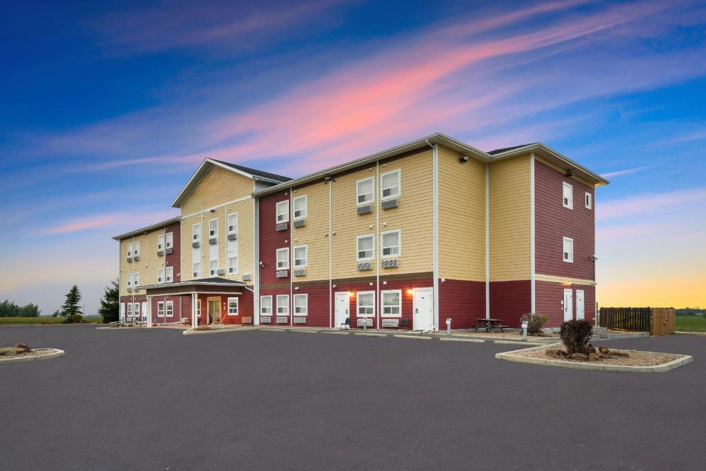 ein großes Wohnhaus mit Parkplatz in der Unterkunft Elk Island Studios - Lamont in Lamont