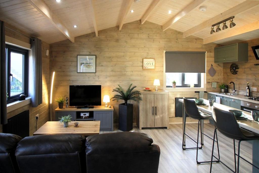 a living room with a couch and a kitchen at Connemara luxury log out in Camus Eighter