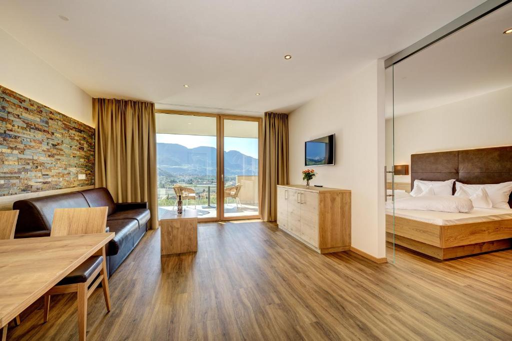 a bedroom with a bed and a couch and a table at Panorama Residence Öhlerhof in Lagundo