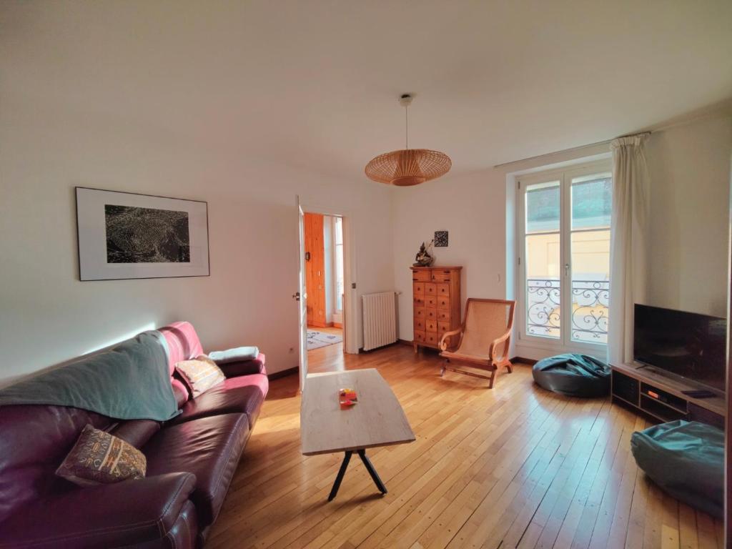 a living room with a couch and a table at Les Capucins - Élégance au Cœur de Remiremont in Remiremont
