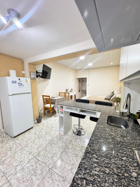 a kitchen and living room with a white refrigerator at Fortuna Apart in General Roca