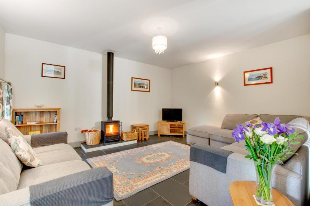 a living room with two couches and a fireplace at 3 Bed in Totnes oc-bcdart in Broadhempston