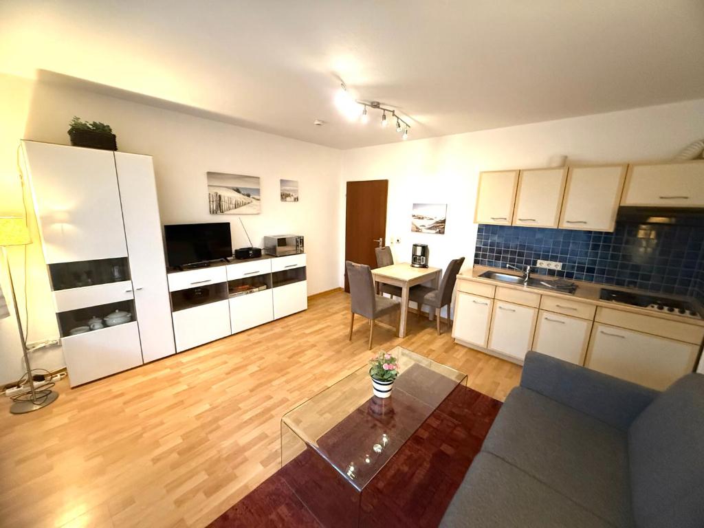 a living room with a couch and a table in a kitchen at Strandmuschel in Norddeich