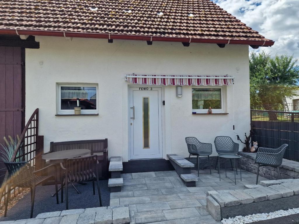 a house with a patio with chairs and a table at EderseeGlück - Fewo 3 ebenerdig klimatisiert in Edertal