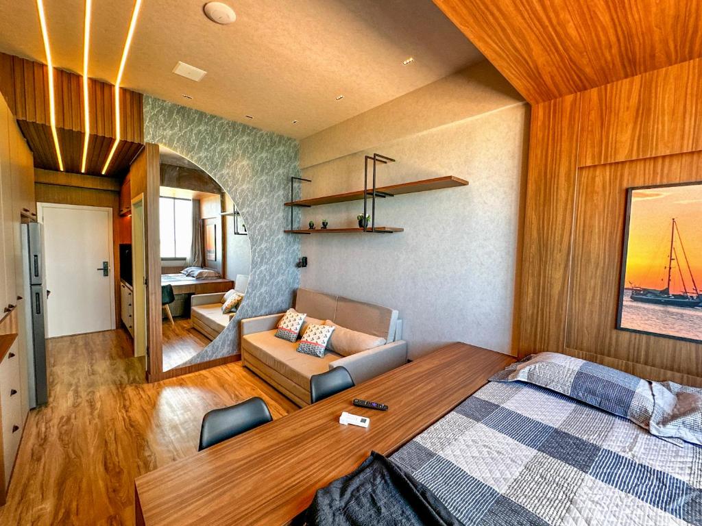 a bedroom with a bed and a living room at Studio Moderno e Completo in Aracaju