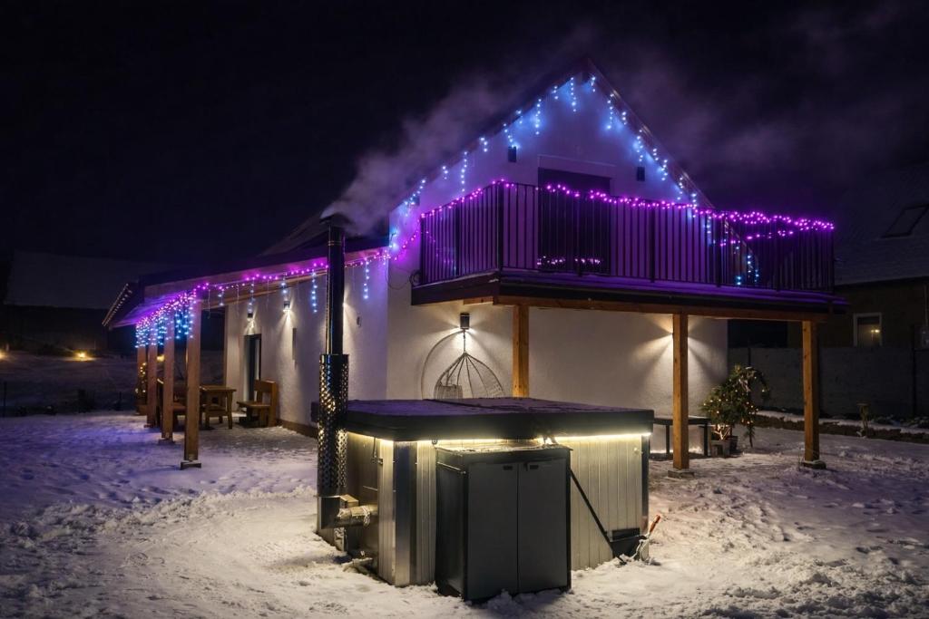 a house with purple christmas lights on the roof at Stodoła in Brenna