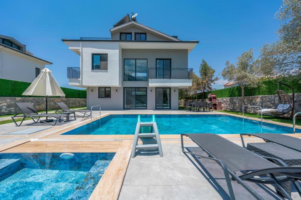 a villa with a swimming pool and a house at Villa Olivin in Fethiye