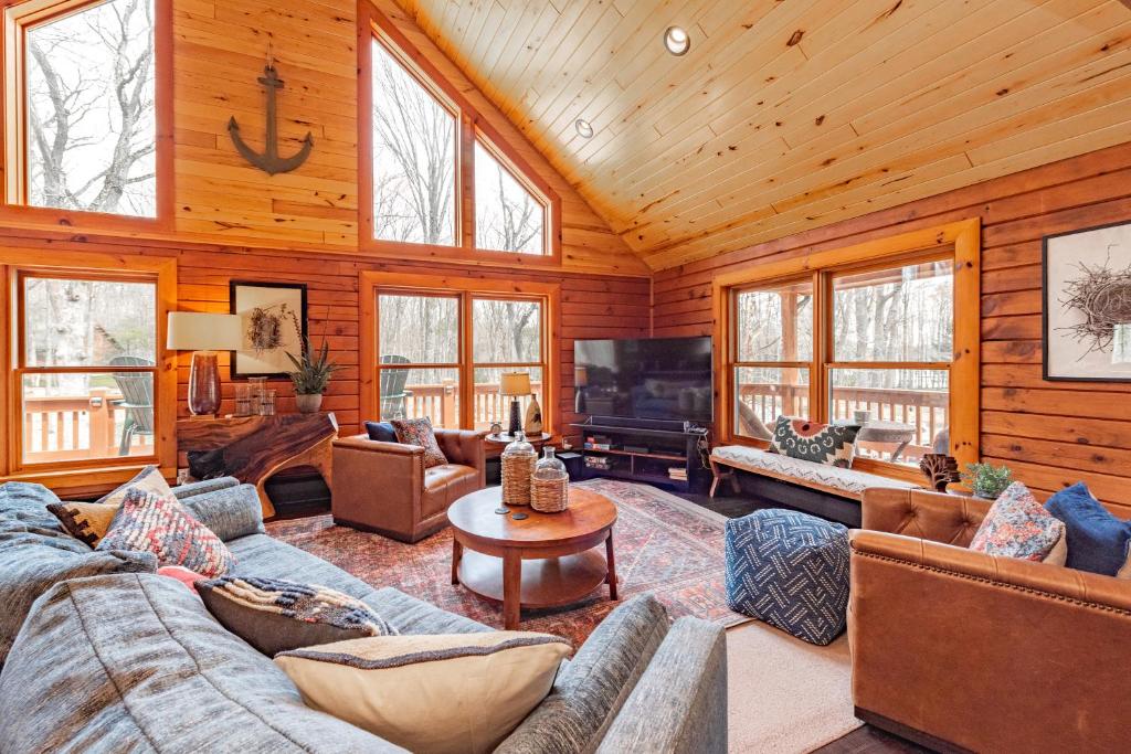 a living room with couches and a tv in a cabin at Crows Nest by Railey Vacations in Swanton